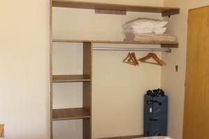 佩休尼亚镇El Arrayan的一间卧室配有木制架子和一张位于客房内的床