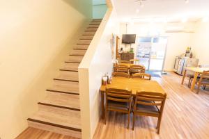 渡嘉敷村kamekamehouse的一间带桌椅和楼梯的用餐室