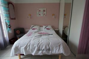 Arthez-de-BéarnO'jardin的一张床上有白色床单和粉红色的鲜花