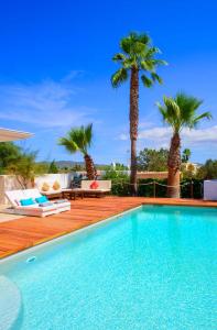 圣安东尼奥湾Villa Melody的一座拥有两棵棕榈树的游泳池和一座庭院