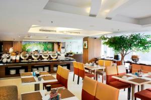 泗水泗水阿拉纳酒店的一间带桌椅的餐厅和一间酒吧