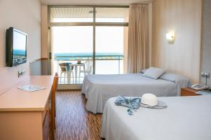 拉梅特拉·德·玛尔RVHotels Hotel Ametlla Mar的酒店客房设有两张床和大窗户。