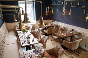 阿尔斯费尔德hôtel villa raab的一间带桌椅和灯光的餐厅
