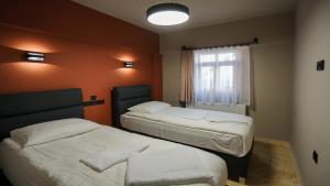 格雷梅Adventure Inn Cappadocia的酒店客房设有两张床和窗户。