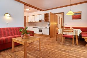弗拉绍森博格度假公寓式酒店的客厅配有红色的沙发和桌子