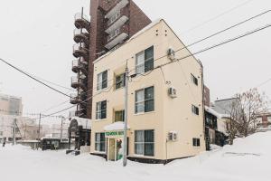 旭川TKD HOUSE Asahikawa的街道上积雪中的建筑物