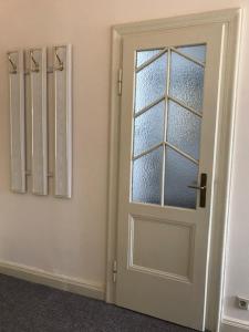 海德瑙厄尔斯酒店的一间房间内的白色门,有玻璃窗