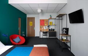 鹿特丹The Social Hub Rotterdam的一间卧室配有一张床和一张红色椅子