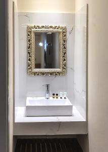 法里拉基奥米洛斯酒店的浴室设有白色水槽和镜子