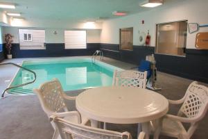 Sawyer索耶速8酒店 的游泳池配有桌椅、桌子和桌子