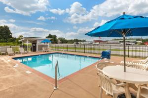 蒙蒂格尔Quality Inn Monteagle TN的一个带桌子和遮阳伞的游泳池
