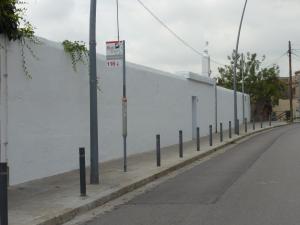 巴塞罗那归尔维拉洛公园旅馆的白色墙壁旁人行道上的街道标志