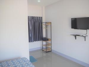 廊开Maharak Resort的一间配有电视的房间和一张位于房间的床