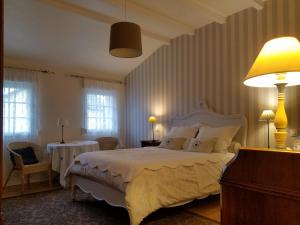 Cattenom克劳斯杜威戈尔住宿加早餐旅馆的卧室配有一张白色的大床和两张桌子