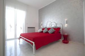 加利波利阿提科迪亚曼特公寓的白色卧室配有红色的床和红色的床单