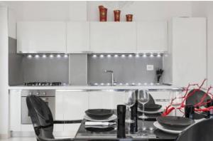 加利波利阿提科迪亚曼特公寓的厨房配有白色橱柜和一张带盘子的桌子