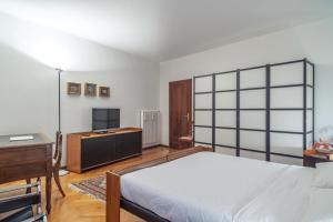 特伦托Casa Mathilda的一间卧室配有一张床、一张书桌和一台电视。