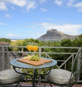 豪特湾dk villas 1 Harbour View Hout Bay的一张桌子,上面放着两杯橙汁和葡萄