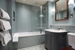 EllastoneThe Duncombe Arms的蓝色的浴室设有水槽、浴缸和水槽