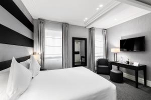 罗马曼奇诺街12号酒店的一间酒店客房,配有一张白色的床和一张书桌