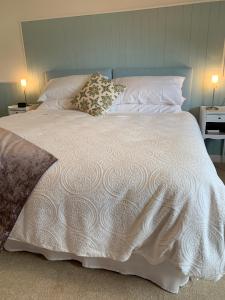 邓迪Dupplin152 bed and breakfast的一张带白色棉被和两个枕头的床