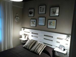 利亚内斯Las endrinas的卧室配有木制床头板,墙上挂有图片