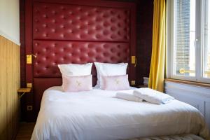 敦刻尔克Les chambres du Waterzooi的一间卧室配有一张大床和红色床头板