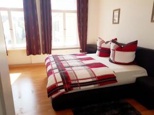 阿尔滕堡Pension Altenburg City的一间卧室配有红色和白色枕头的床