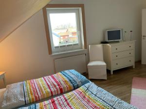 齐罗Aamon的一间卧室设有一张床、一台电视和一个窗口。