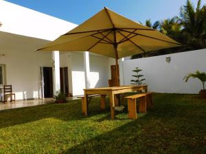 达喀尔Villa Ty Milyn Mazela SA的院子里带雨伞的野餐桌
