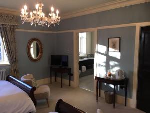 布莱克伍德Gellihaf House的一间卧室配有一张床、一张书桌和一个吊灯。
