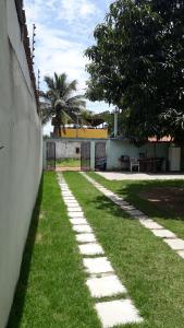 丰当Casa de praia P Grande的墙上旁的草上走道