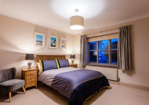 布莱克尼Bramble Lodge的卧室配有床、椅子和窗户。