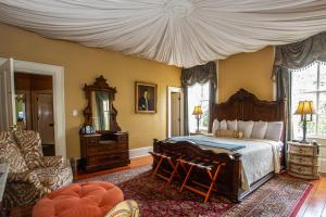 萨凡纳Eliza Thompson House, Historic Inns of Savannah Collection的一间卧室配有一张带天蓬的大床