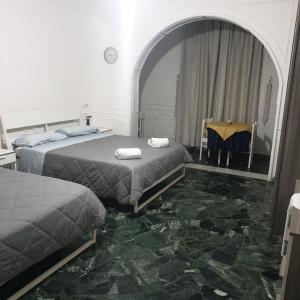 巴里B&B GANAJ - Corso Italia 89 - BARI的客房设有两张床和一张带镜子的桌子