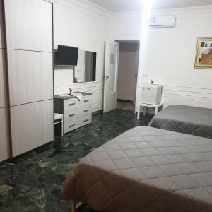 巴里B&B GANAJ - Corso Italia 89 - BARI的一间卧室配有一张床、一张书桌和一台电视