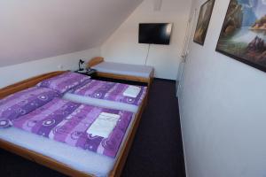 RudníkK旅馆的一间卧室配有一张带紫色棉被的床