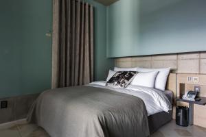 首尔首尔麻谷SR酒店的一间卧室配有一张蓝色墙壁的床