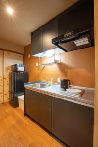 金泽marutto Ishikawa的厨房配有水槽和冰箱