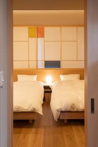 金泽marutto Ishikawa的一间设有两张床的房间和一扇通往卧室的门