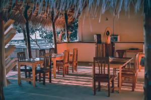 内布拉拉Mulia Bungalows的用餐室配有木桌和椅子