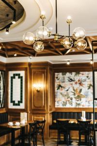 秋明Hotel England Tyumen Center的一间带桌椅和吊灯的用餐室