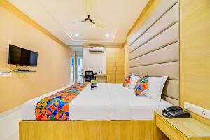 海得拉巴FabHotel Viraj Suites Gachibowli的一间卧室配有一张大床和电视