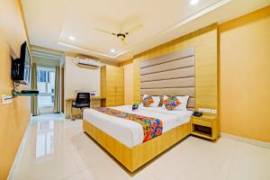 海得拉巴FabHotel Viraj Suites Gachibowli的配有一张床和一张书桌的酒店客房