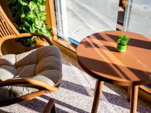 北谷町The Moana by DSH Resorts的木桌和椅子,上面有盆栽植物