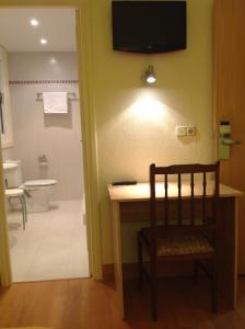 伊伦利扎索旅馆的一间带书桌和卫生间的浴室以及一台电视。