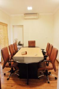 钦奈Niketana @ Boat Club的一间会议室,配有桌子和皮椅