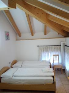 Pieve Tesino塔克斯旅舍的一间带四张床的卧室,位于带木制天花板的房间内