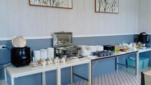 亚兰OB-Oon Resort的一间房间,配有两张带食物的白色桌子