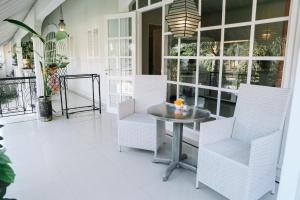 塞米亚克Casa Artista By Kresna Hospitality的门廊配有白色的椅子、桌子和窗户